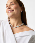 Woman wearing a pearl necklace against a white background