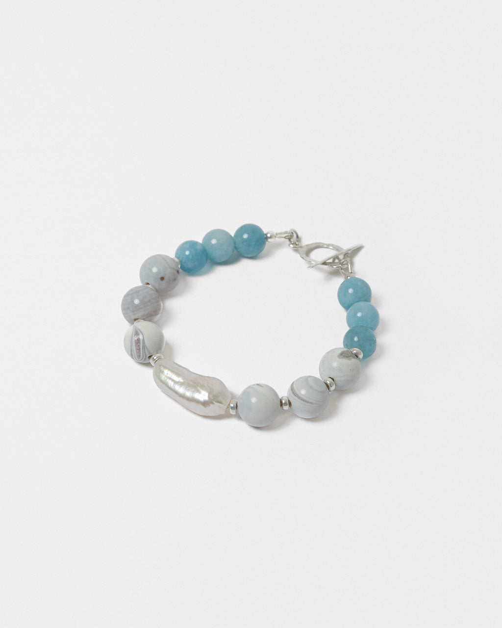 Bracelet with blue beads and a pearl on a white background