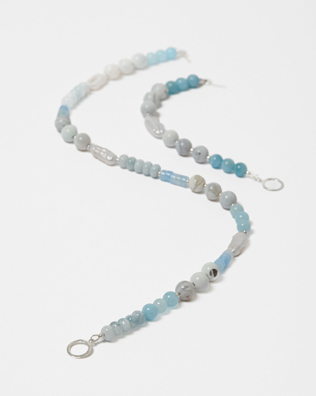 Beaded jewellery with blue and freshwater pearl beads on a white background