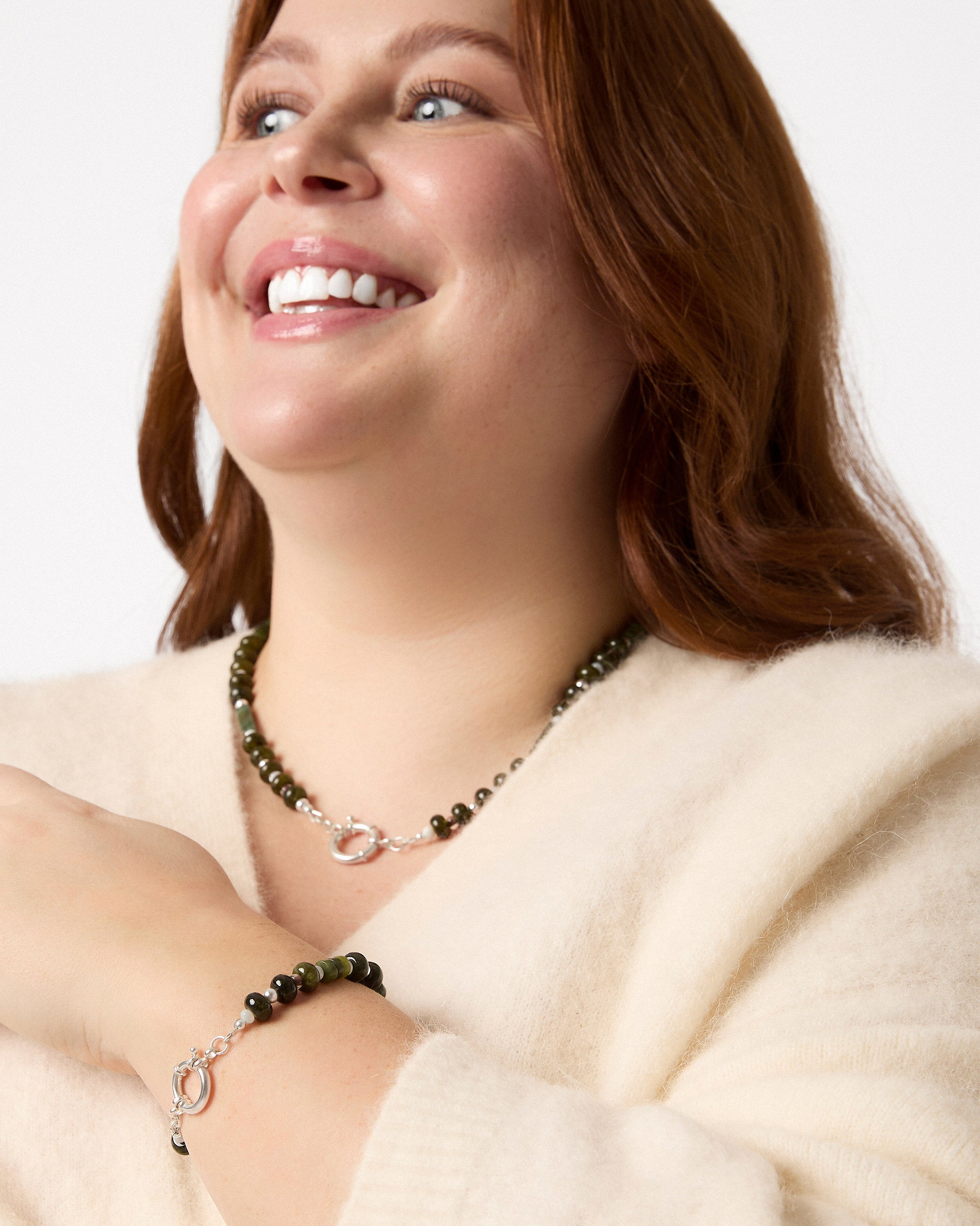 Woman wearing a necklace and bracelet with a white background