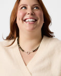 Woman wearing a necklace with a plain background