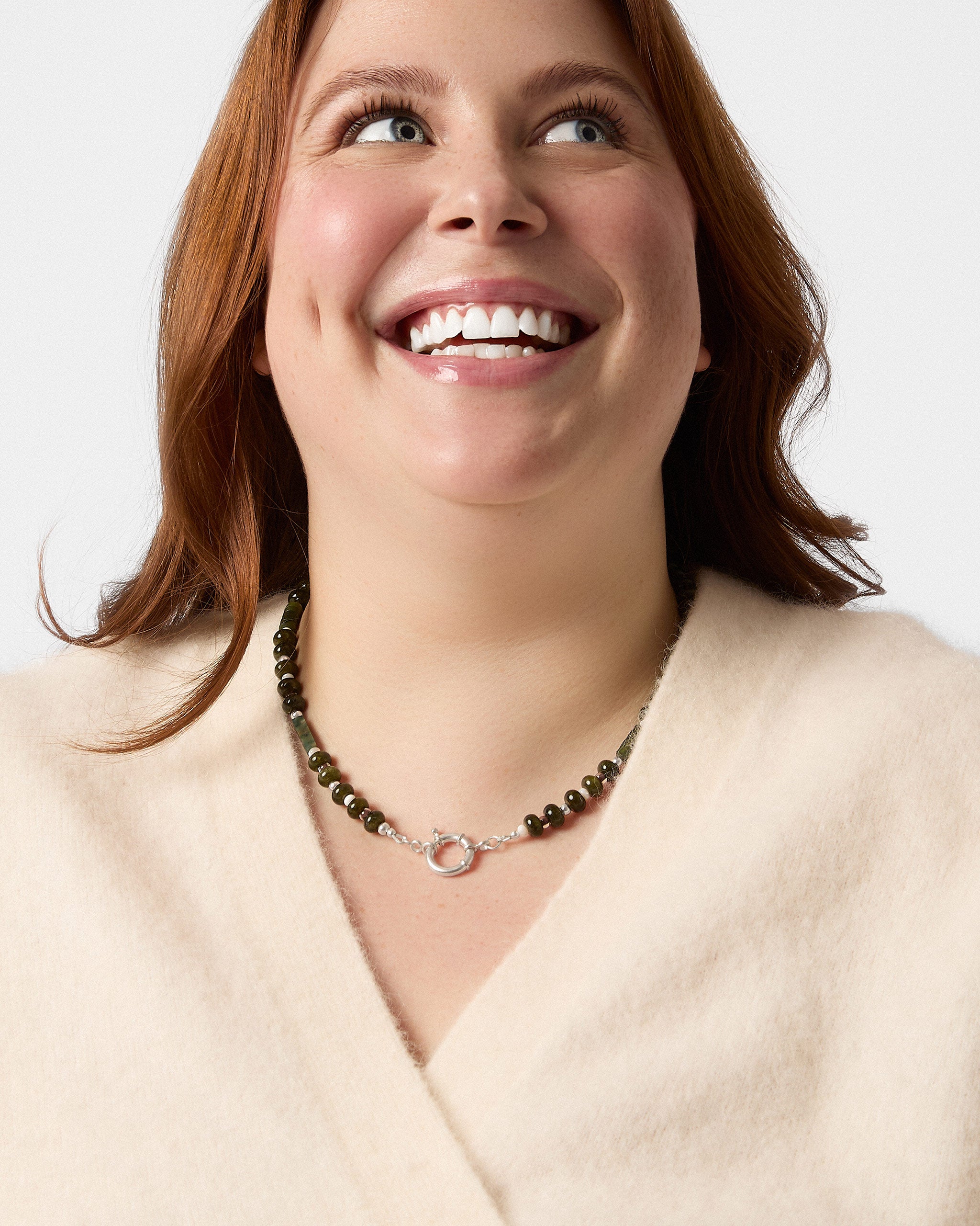 Woman wearing a necklace with a plain background