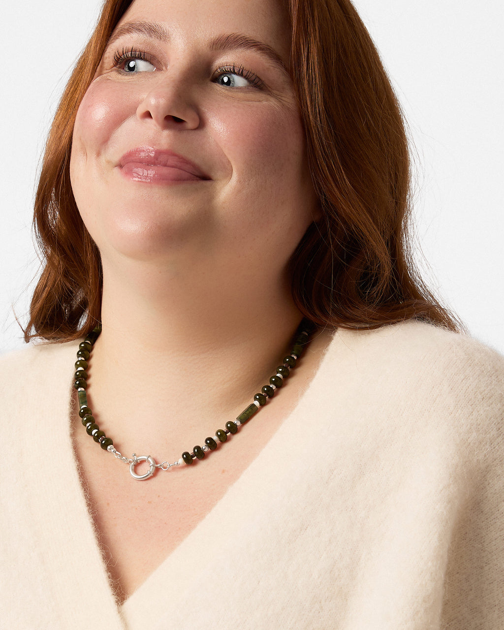 Woman wearing a necklace with a plain background