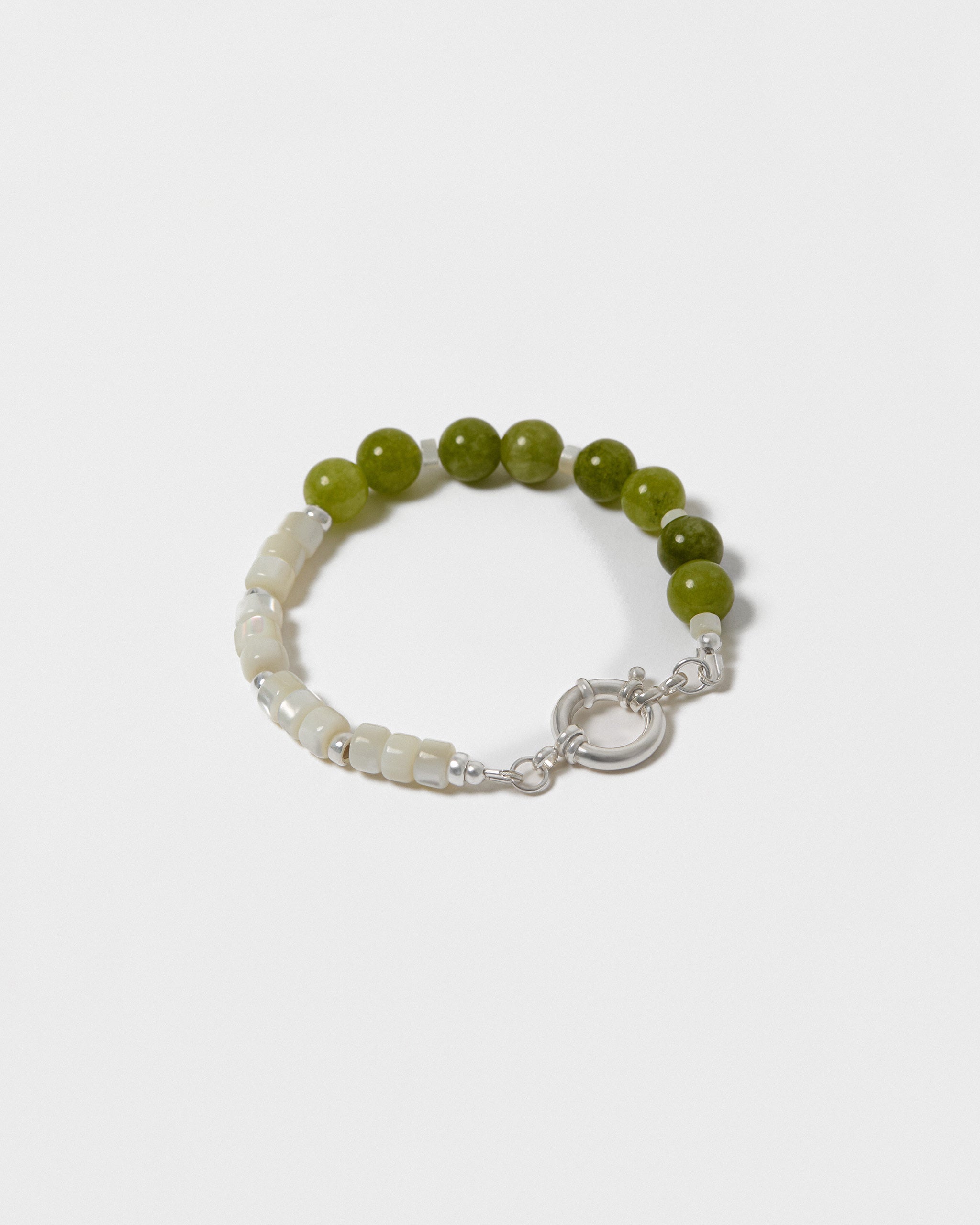 Bracelet with green and white beads on a white background