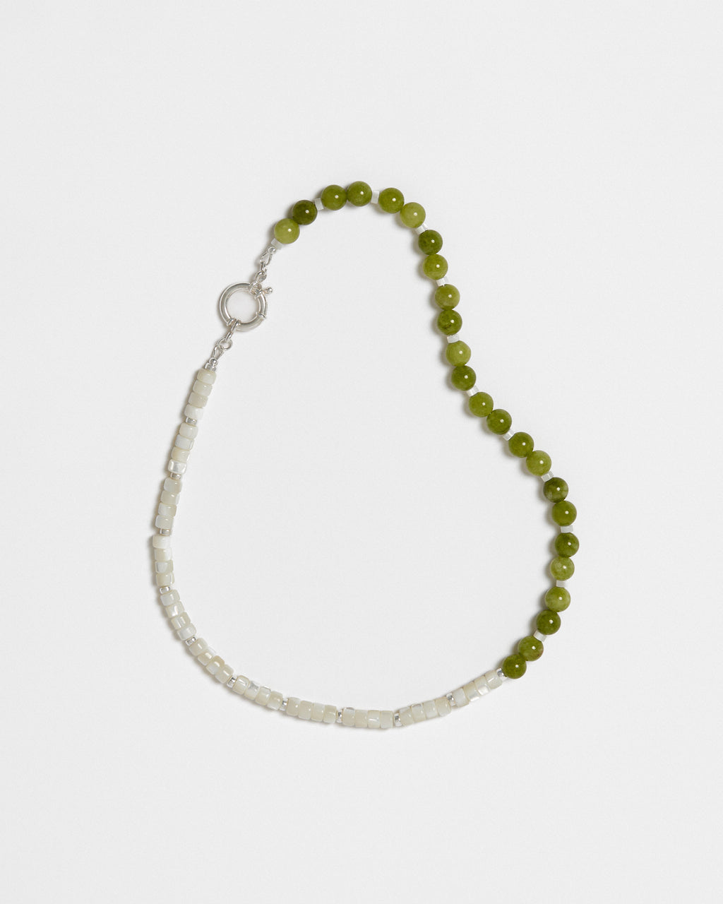 A beaded necklace, made out of white and green beads, on a white background