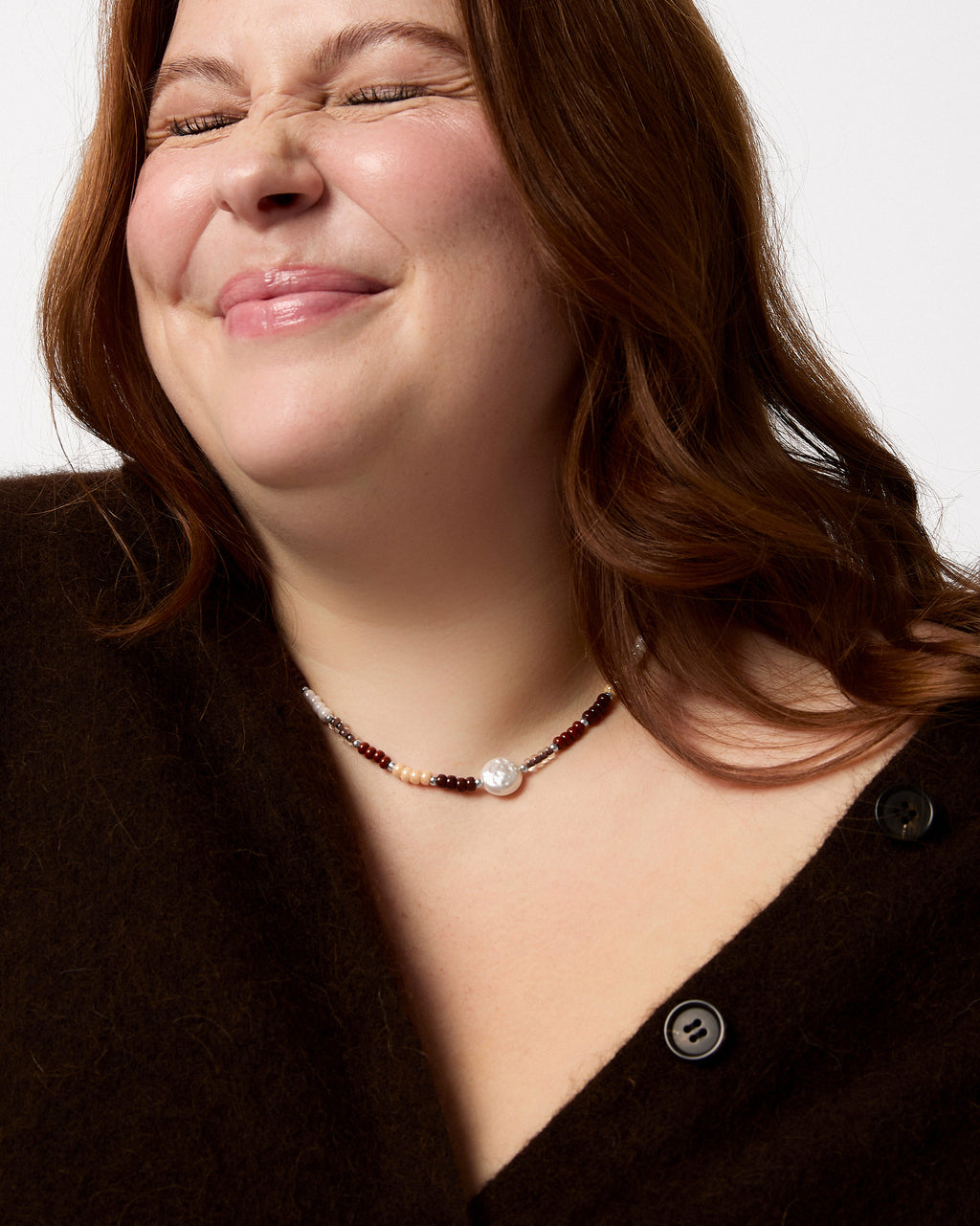 Woman wearing a necklace with a plain background