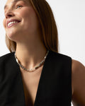 Woman wearing a necklace against a plain background