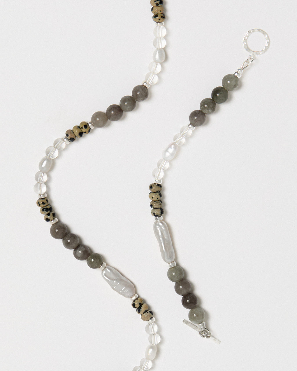 Beaded necklace with gray and white beads on a white background