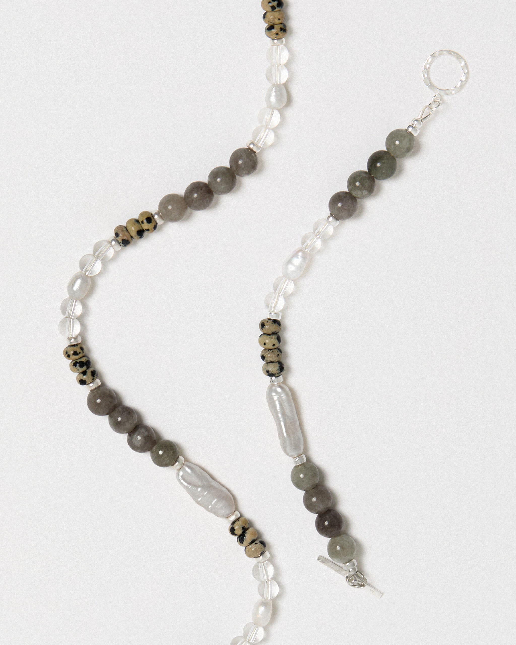 Beaded necklace with gray and white beads on a white background