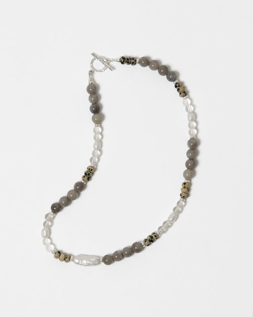 Beaded necklace with gray and white stones on a white background