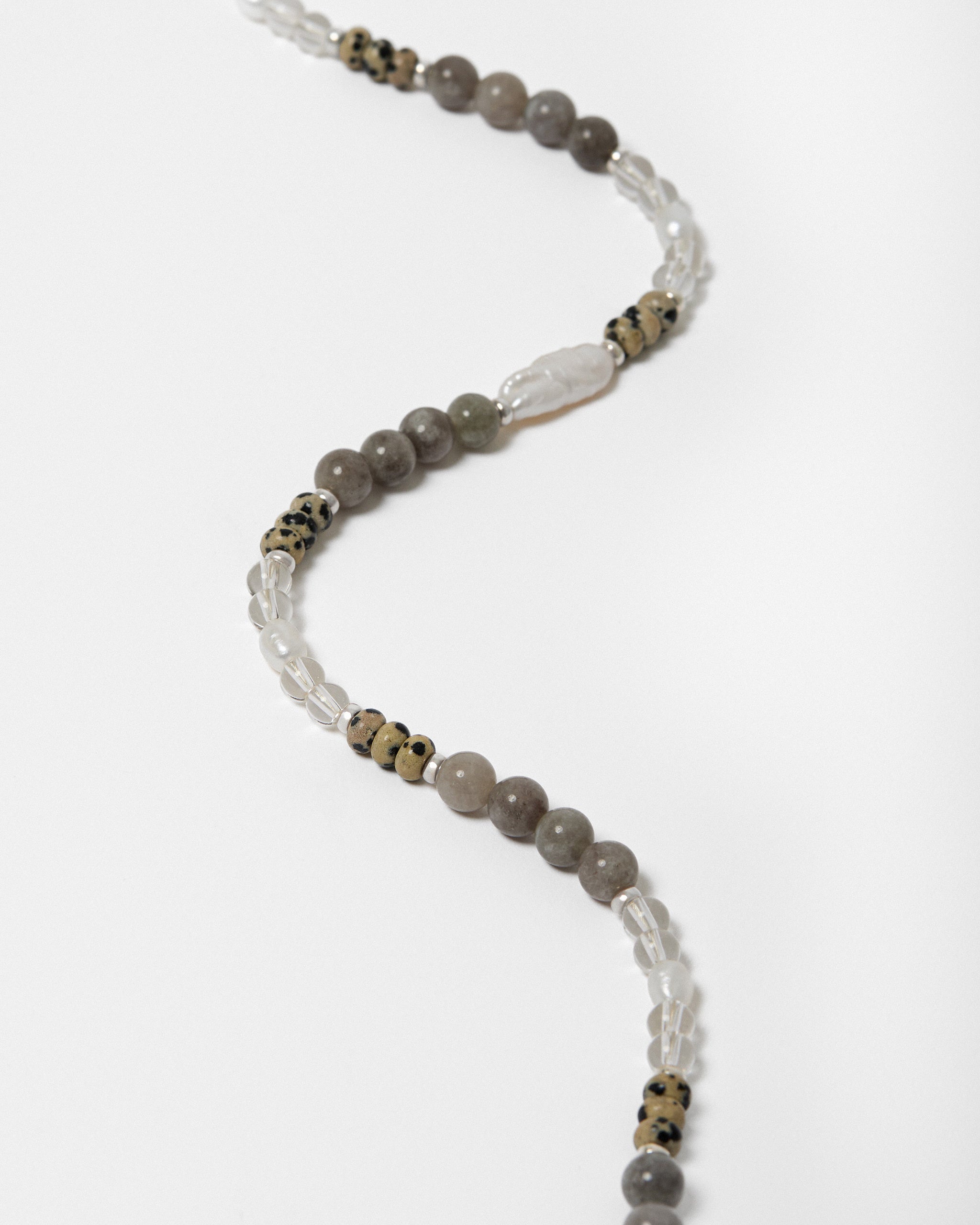 Beaded necklace with gray and white beads on a white background